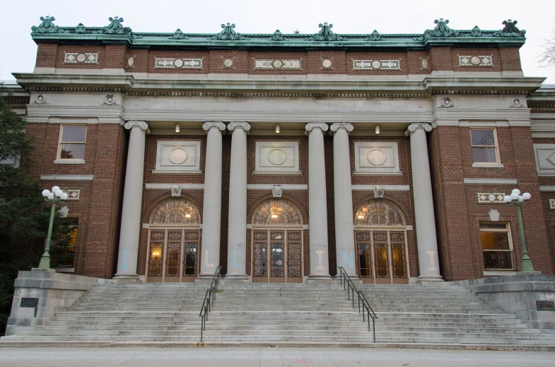 the building has several pillars, lights and a clock on it