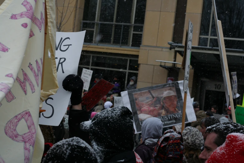 people gathered together holding up protest signs and flags