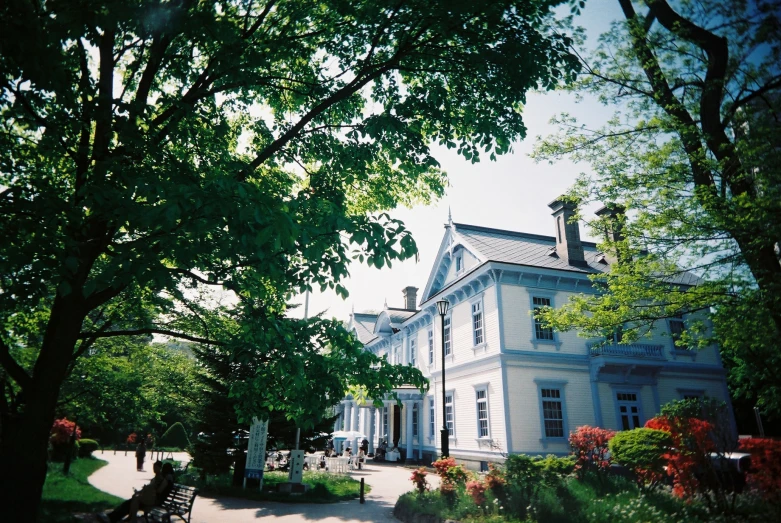 an empty walkway in front of a large blue house