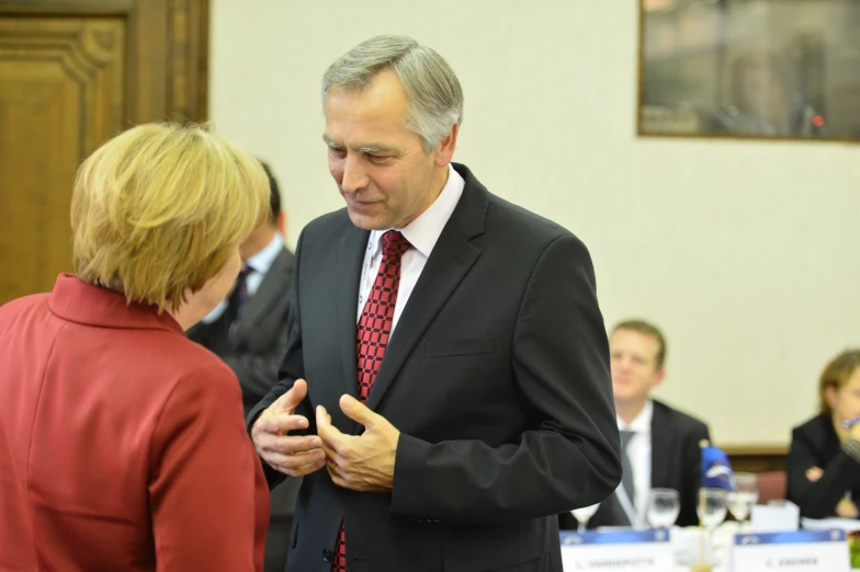 a man is talking to another man in front of people at a conference