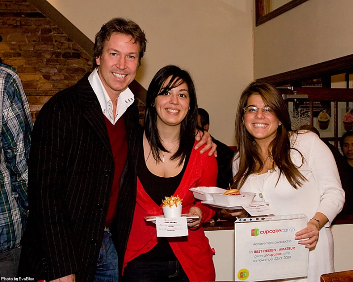 a man and three woman holding a box of food