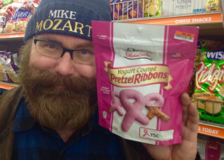 man in hat holding up bag of frozen coffee