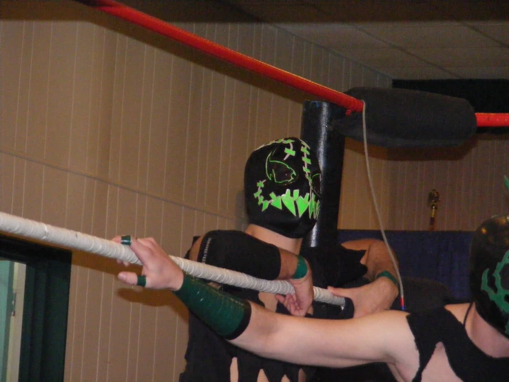 two boys wearing their wrestling gear and masks with a ring