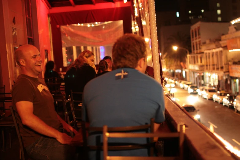 people sitting at a table with one person on a cell phone