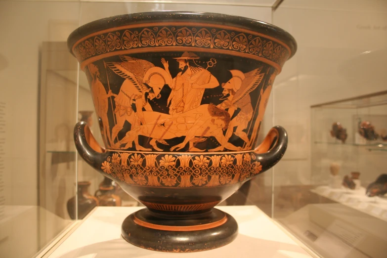 an ancient vase in a museum with many other vases and pottery