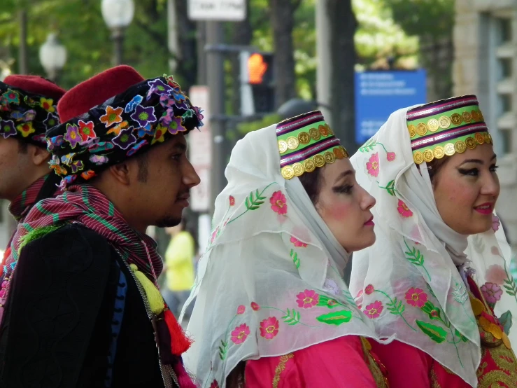 two men and three women dressed in colorful clothing