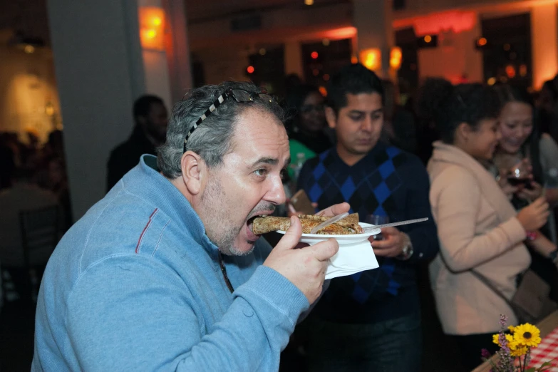 an image of a man eating food at a party