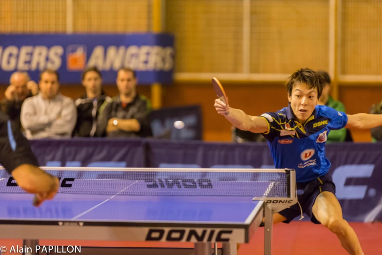 a ping pong table with a table ball racket and a person raising their arm to touch the table