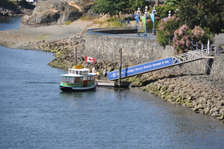 a long white boat traveling through a marina next to a small boat ramp