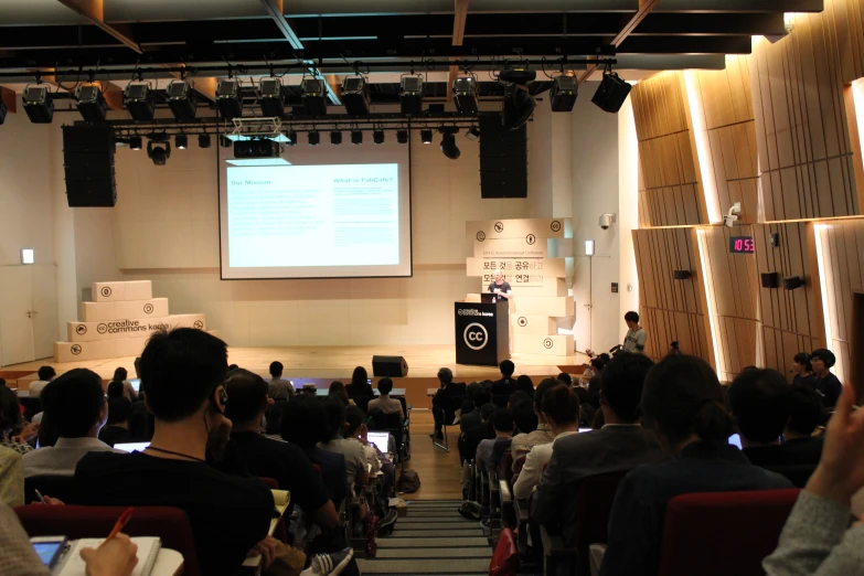 a group of people watch an lecture on the stage