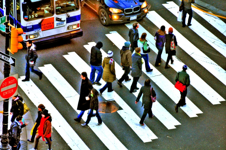 a crowd of people walking across a crosswalk