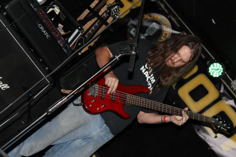 a man playing guitar at the edge of a stage