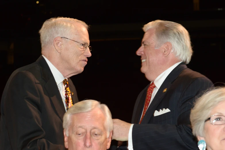 two men standing side by side in front of a crowd of people