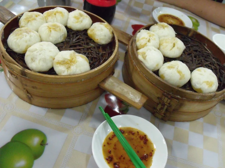 two bowls of banana ding next to a plate of apples