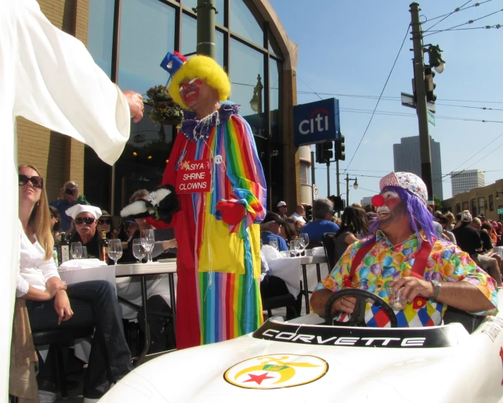 people in clown costume near the front of a racing car