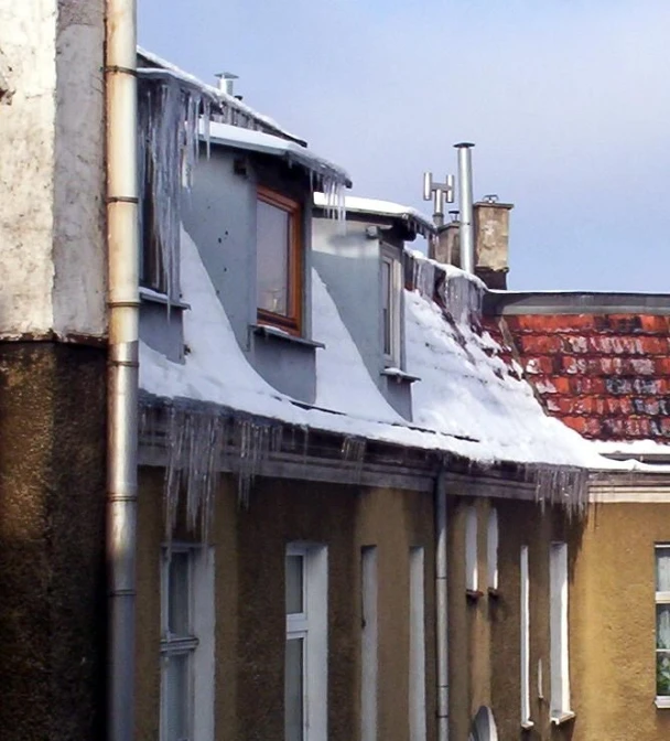 a very snowy rooftop that has snow covered houses