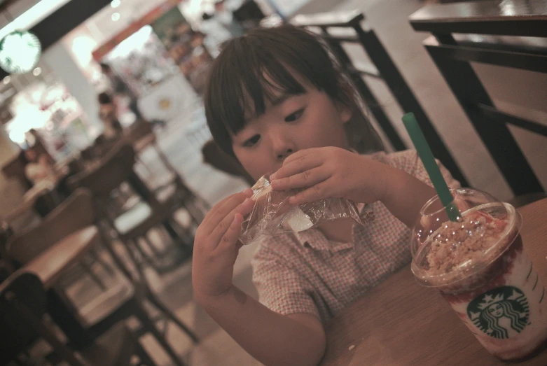 an image of girl eating a snack at restaurant