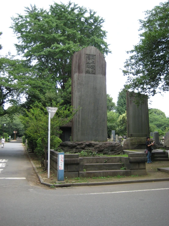 a cemetery with three concrete sculptures sitting on top of a sidewalk