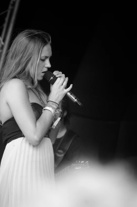 a woman standing next to a microphone at a concert