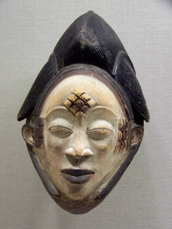 this is a ceramic mask with a bird on it's head