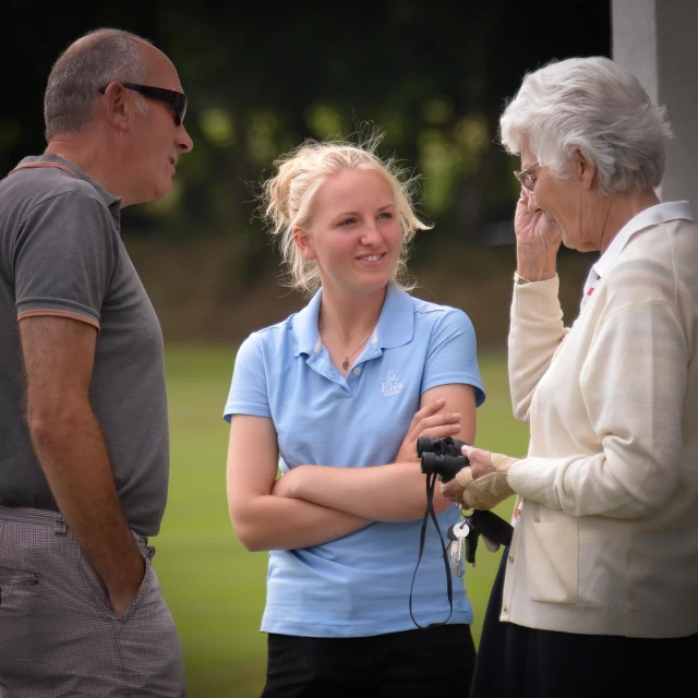 three people standing around while one person holds a camera