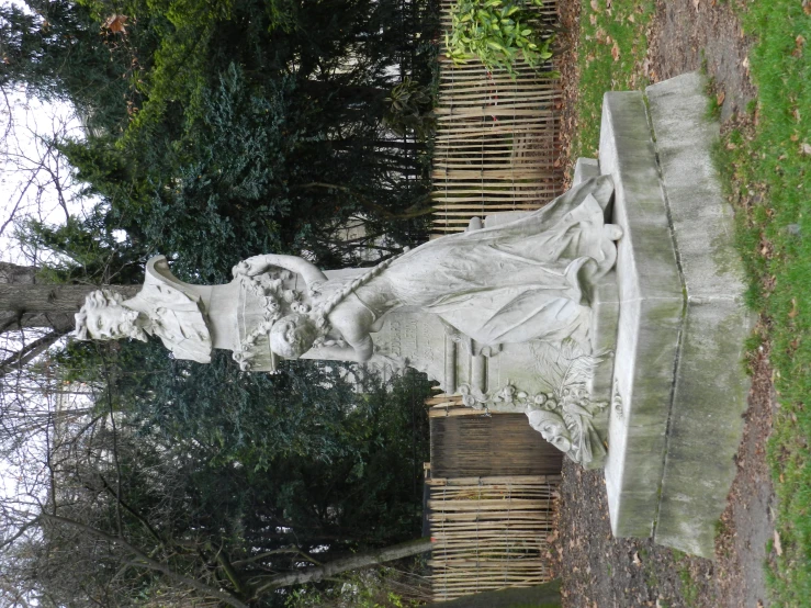 a sculpture on the grass near a tree