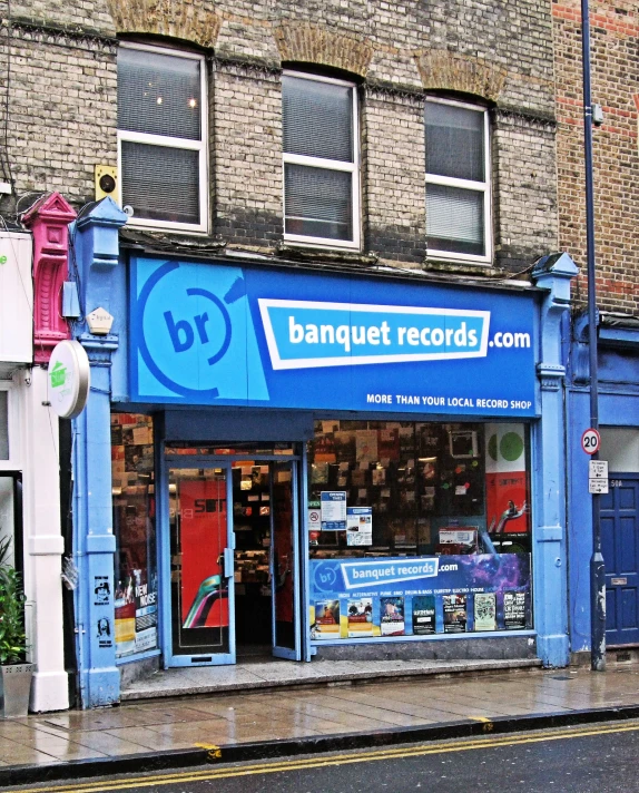 a corner shop with blue walls has the windows opened