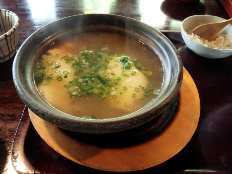 a bowl of soup on top of a wooden table