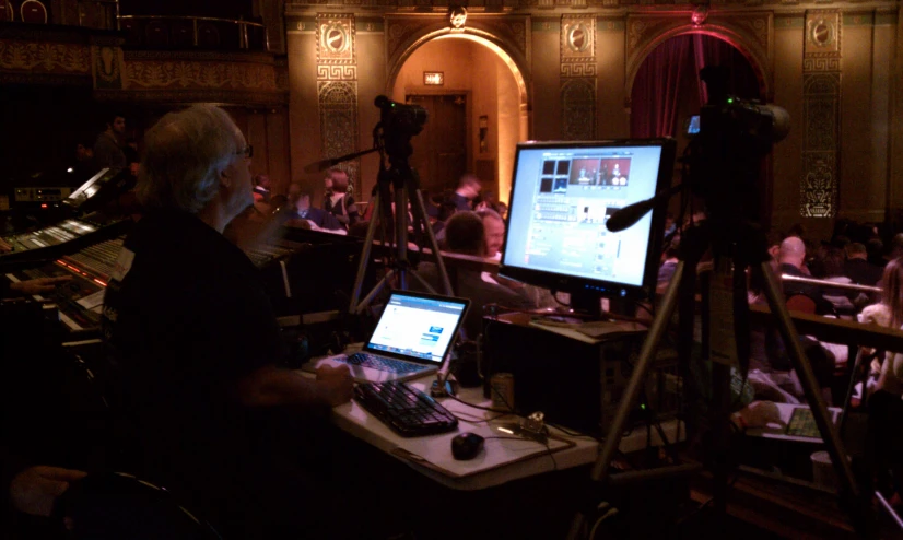 a pographer is recording an event while using the computer