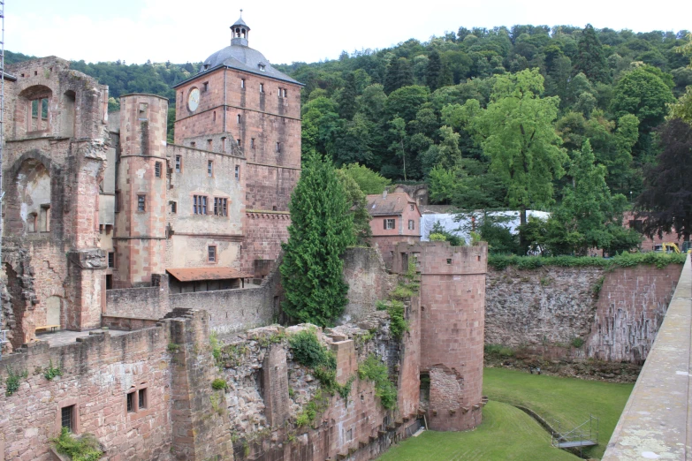 an old castle in front of mountains and forest