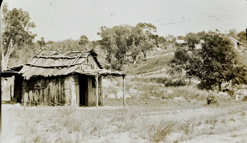 a sepia toned po of an old house on the road