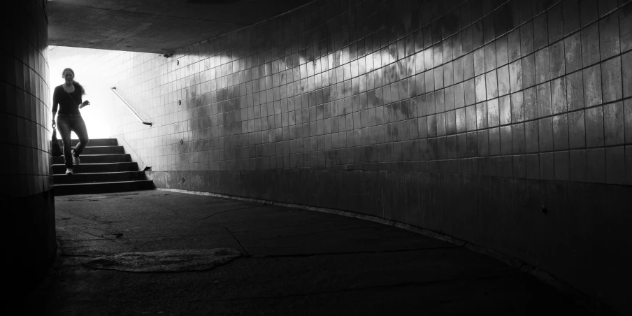 someone standing in the dark looking up a flight of stairs