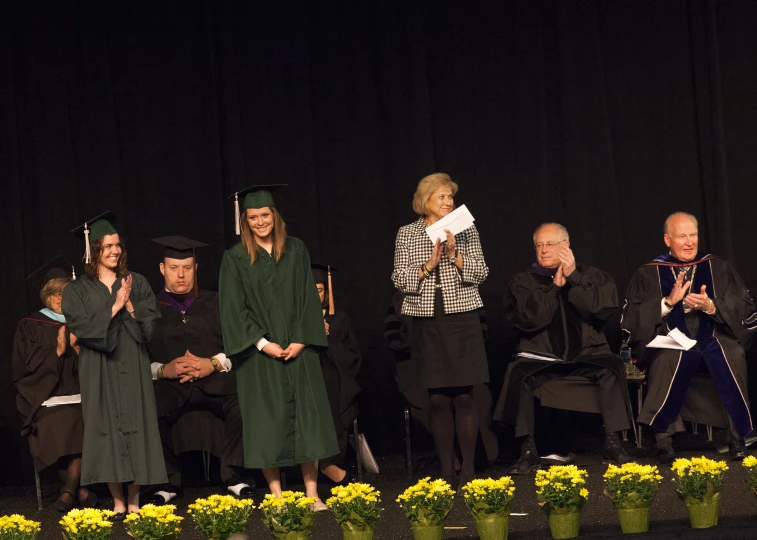 an event with people in graduation gowns and two graduates