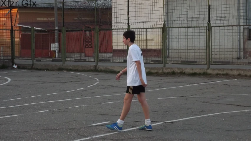 a person on a tennis court walking in shorts