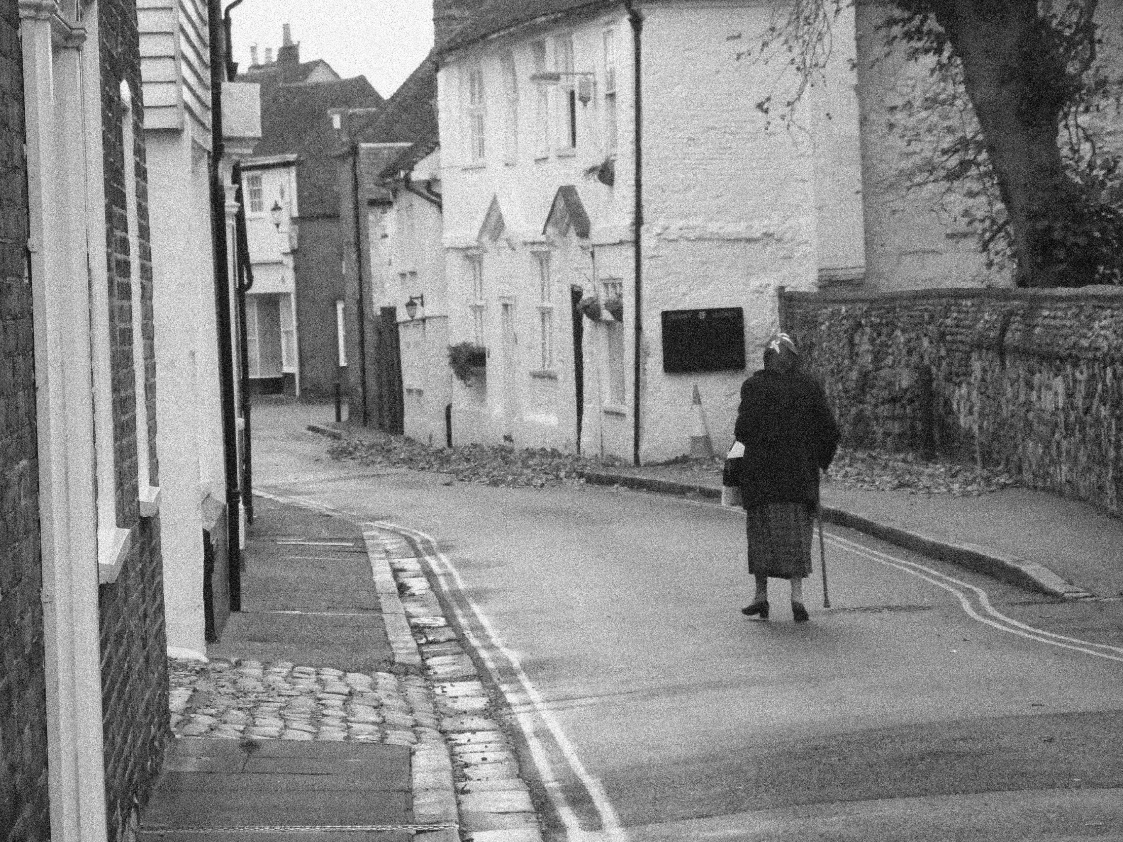 a lady is walking down the road with an umbrella