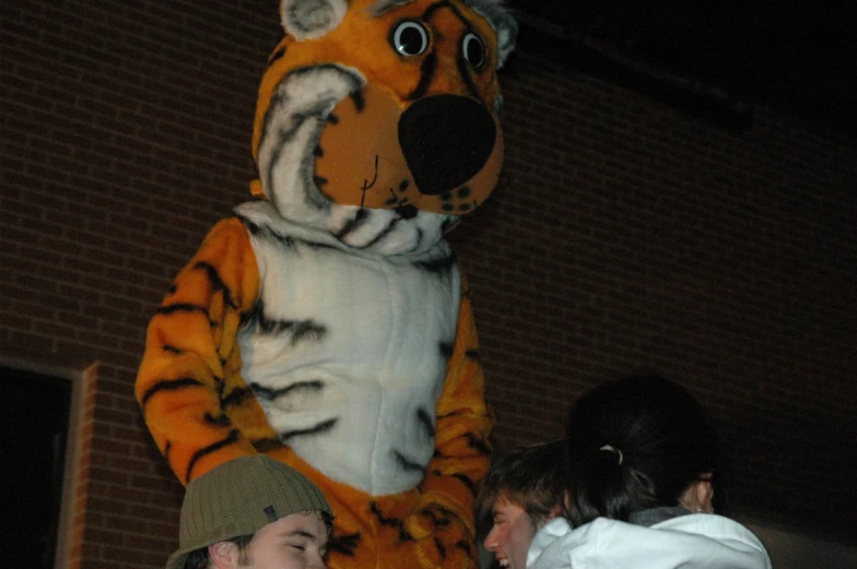 a man and woman standing next to a stuffed tiger