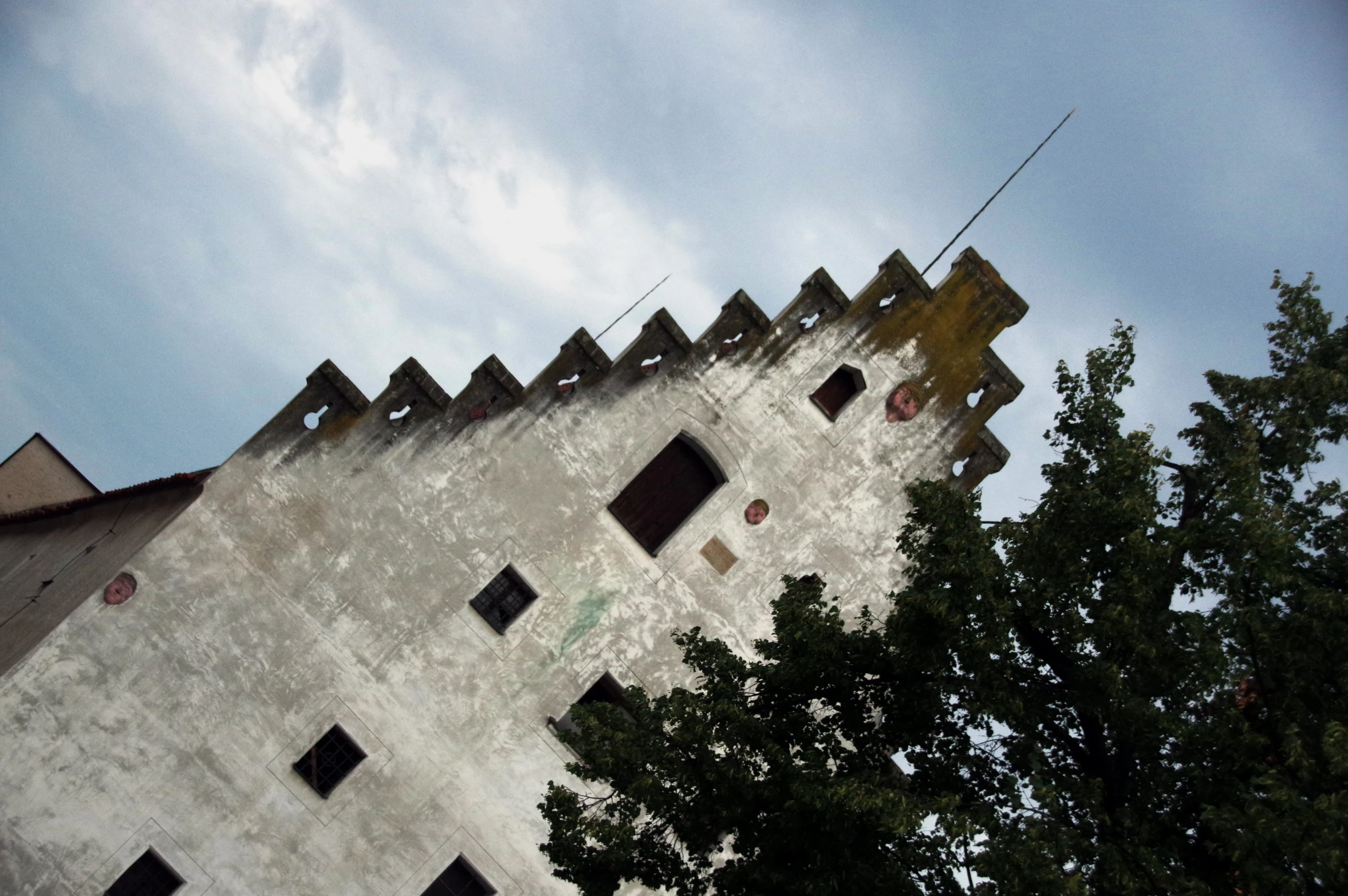 a very tall brick building with windows and a fence in front