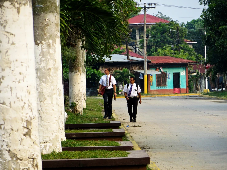 people in school uniforms walk down the street