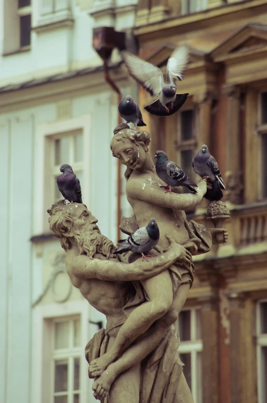 a sculpture of woman and several pigeons on the back