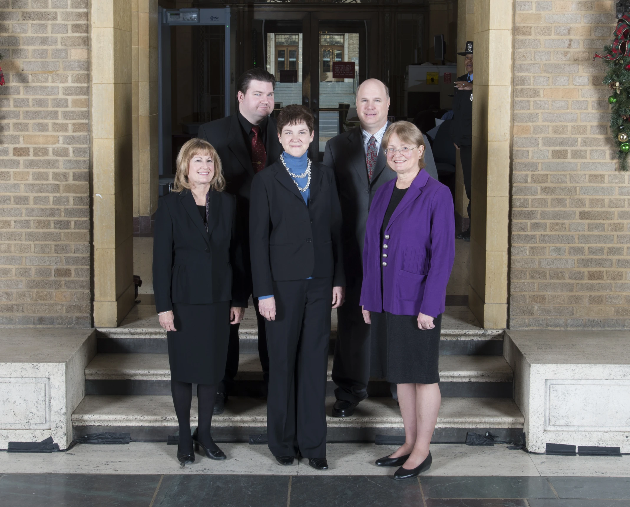 four business people in front of an entrance