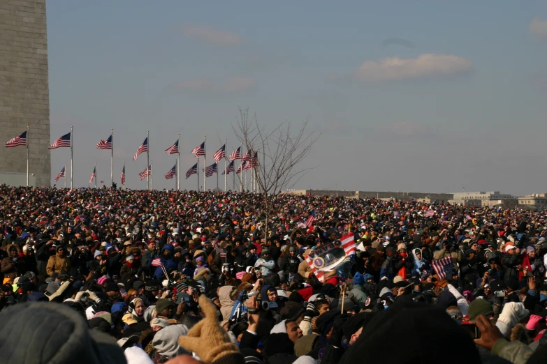 a large crowd of people standing in front of a statue