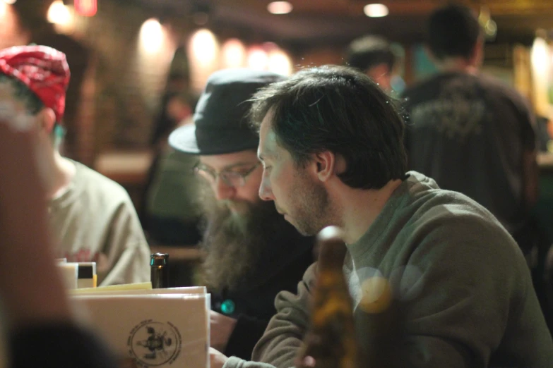 men sitting at a table with beers in front of them