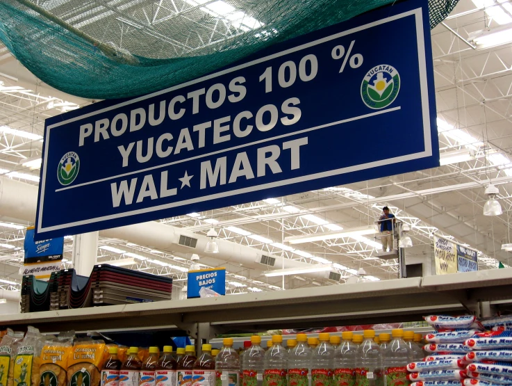 blue and white sign above store shelves in grocery store