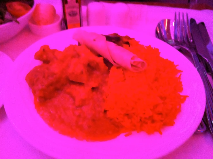 a plate of food sits next to silverware on a table