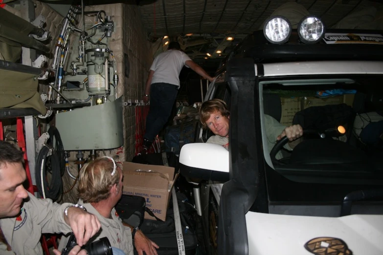 people inside of an industrial building with a truck