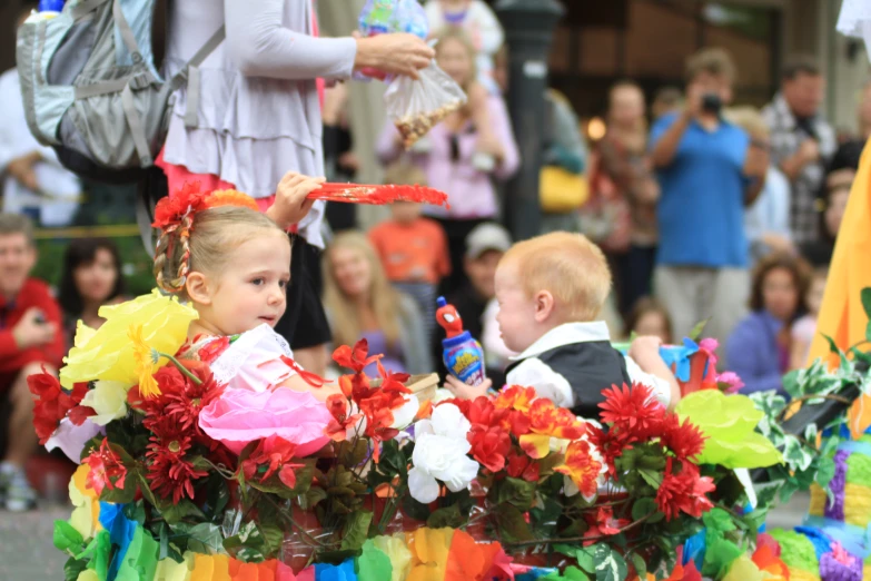 children dressed up in costume and standing near onlookers