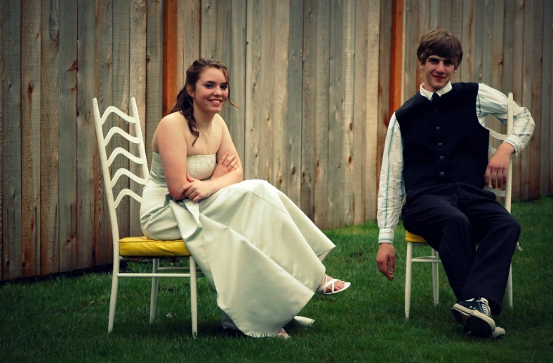 young married couple pose next to a wooden fence