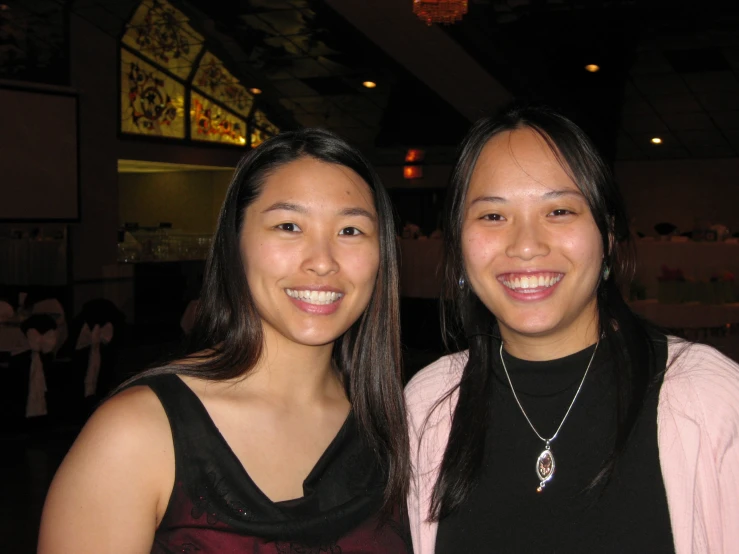 two women posing for a po in a dark setting