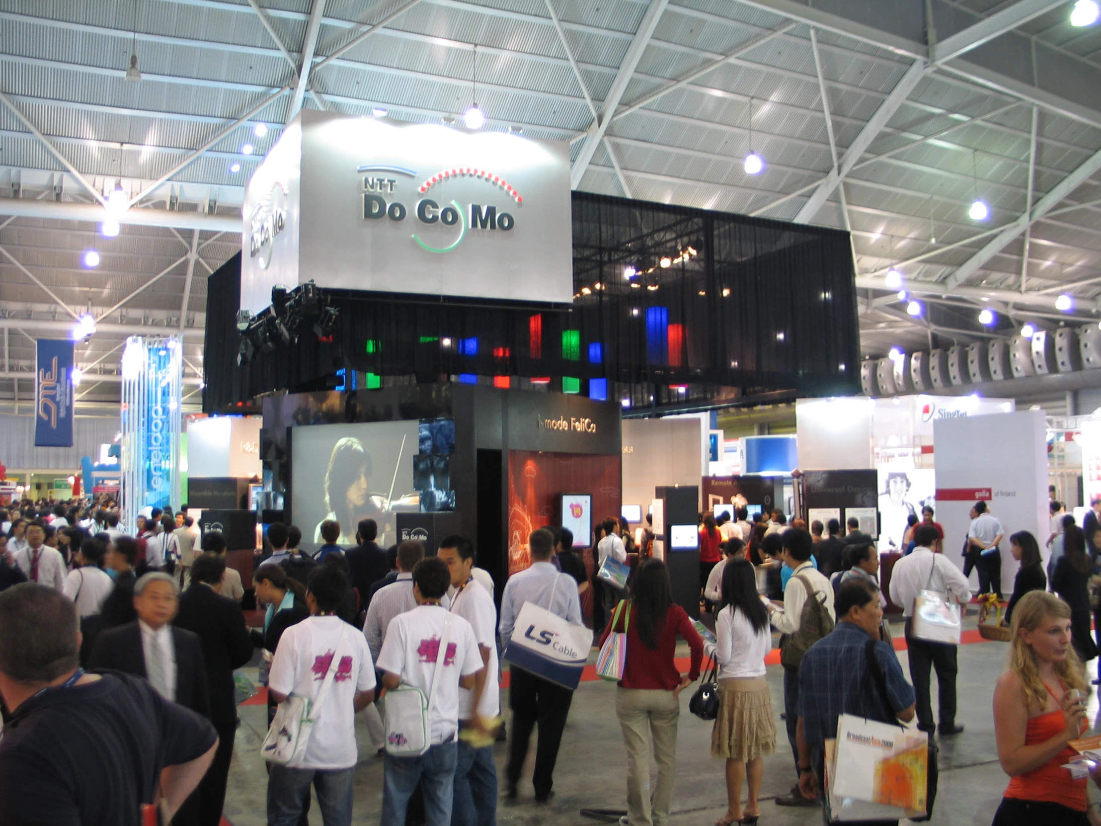 a large group of people standing around at an exhibit