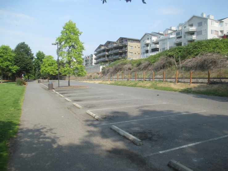 an empty parking lot on a hill above apartment buildings